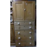 A antique stripped pine Tallboy, with a two panelled door cupboard, above a chest of five graduating