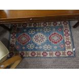 Tribal Rugs; two pale blue ground small rugs, each with stylised geometric patterns in cream,