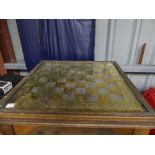 An early 20thC oak Games Table, the square top with brass effect chess board, raised on barley twist