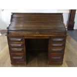 An early 20thC American oak roll top Desk, marked 'Cutler', the serpentine tambour front revealing