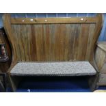 A vintage pine high back Settle, with scrolling end supports, 64in (162cm) wide, 18in (45.5cm) deep,