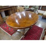 A Victorian walnut oval Breakfast Table, quarter veneered top above a deep frieze, turned quatre-