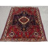 Tribal rugs; a Persian Qashqai red and blue ground rug, the whole woven with stylised tree of life