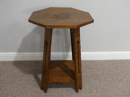 An Arts and Crafts octagonal Occasional Table, the four splayed supports carved with an Arts and