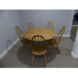 A mid 20thC Ercol elm and beech drop leaf Dining Table, the elm plank top on splayed tapering