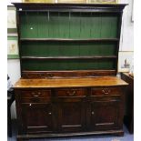 A George III oak and elm Dresser, the dentil cornice above shelves, small drawers and an enclosed