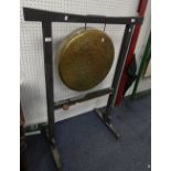 A vintage circular Brass Gong, with striker, on a later floor standing painted wooden stand, the