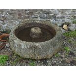 An antique granite circular Grinding Trough, 40in diameter x 15½in high (102cm x 39cm). Note; This