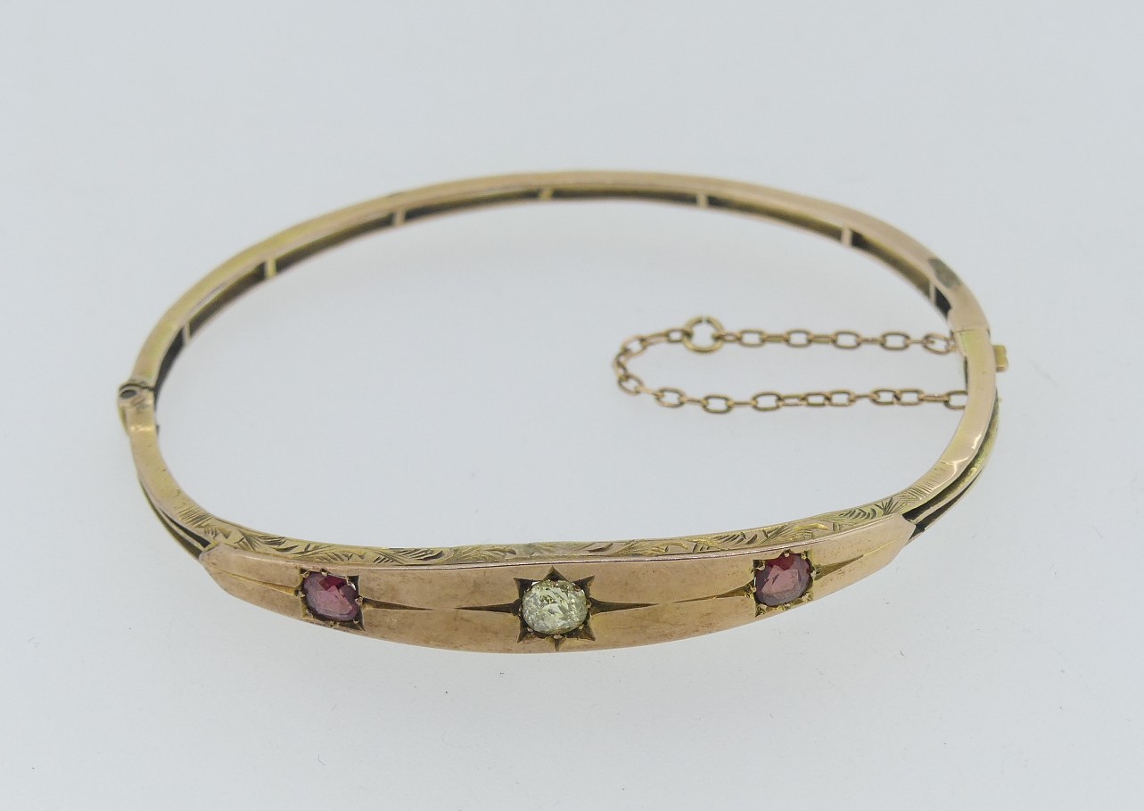 A 9ct gold narrow hinged Bangle, with flared front, gypsy set in the centre with a diamond and