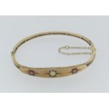 A 9ct gold narrow hinged Bangle, with flared front, gypsy set in the centre with a diamond and