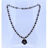 A haemitite and gold Necklace, formed of alternate black and grey beads with a gold ring between
