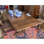 An antique carved oak draw-leaf Dining Table, the rectangular top above a carved frieze on a trestle