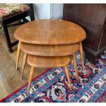 A vintage Ercol nest of three Pebble Tables, largest 65cm x 44cm x 40cm, all needing stripping