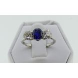 A three stone sapphire and diamond Ring, the central oval sapphire with a brilliant cut diamond on
