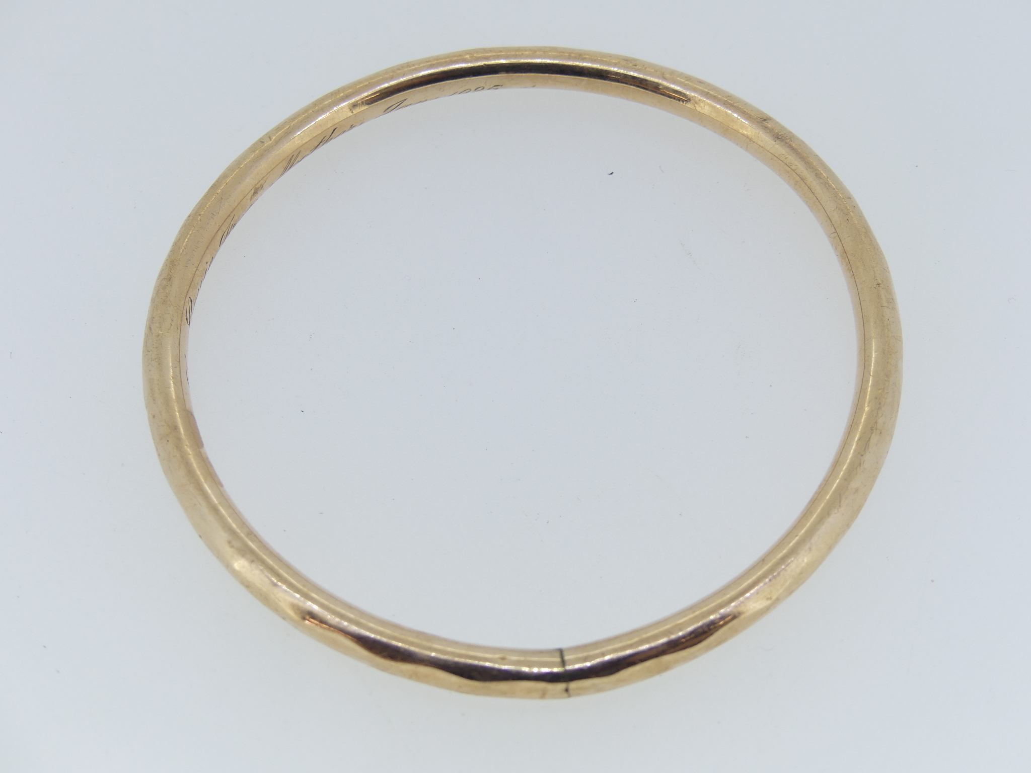 A 9ct rose gold hollow Bangle, with inscription, approx weight 9.5g.