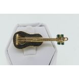 A novelty 14k yellow gold Brooch, modelled as a guitar, set with four small emerald 'key winders',