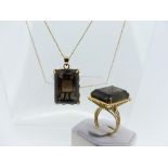 A rectangular smokey quartz Pendant, claw set in a wirework yellow metal mount, all unmarked, the