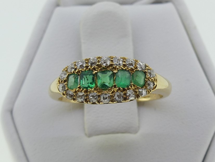 An attractive emerald and diamond Ring, the centre set with five emeralds, with yellow gold