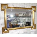 An antique-style giltwood Wall Mirror, the shaped rectangular frame with a bevelled plate and