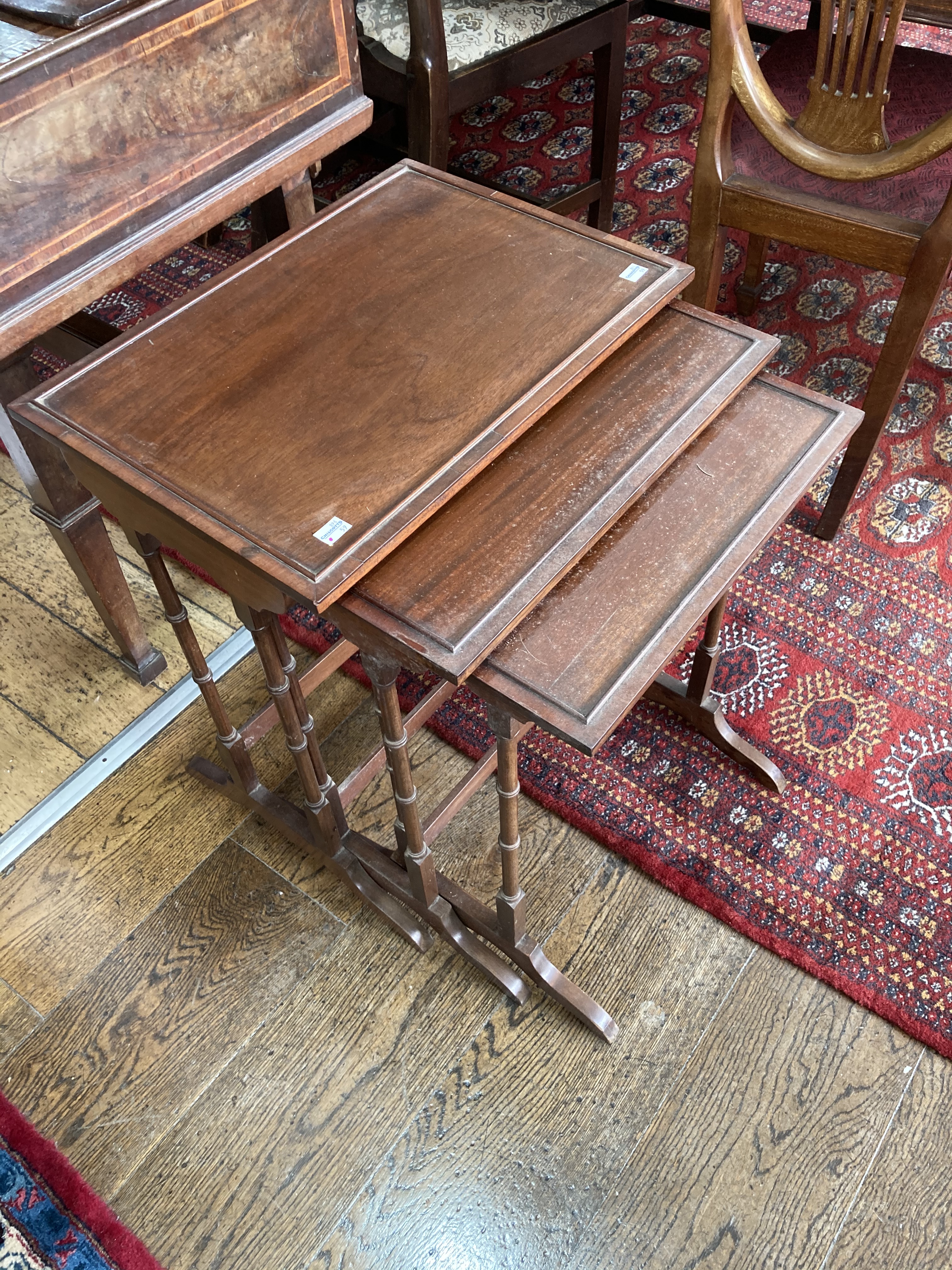 An early 20thC mahogany Nest of three Occasional Tables, with ring turned supports and sledge