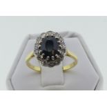 A green sapphire and diamond cluster Ring, the facetted central oval sapphire, 10mm x 7mm approx,