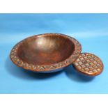 A Tribal geometrically-carved wooden circular Bowl, with protruding circular handle (carved from