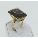 A smokey quartz Dress Ring, the rectangular facetted stone, 2cmx1.5cm mounted in 9ct yellow gold,