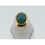 An oval 'scarab' Dress Ring, the faience scarab in rub over yellow gold mount and shank, all
