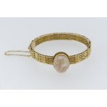 A 15ct yellow gold Hinged Bracelet, of gatelink design, the centre set with a shell cameo of