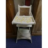 A vintage white painted child's High Chair, with cane back, 20in (51cm) wide, 39in (99cm) high.