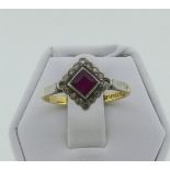 An Art Deco ruby and diamond Dress Ring, the central square cut ruby within a border of sixteen
