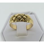 A yellow gold Ring, with flared front engraved with flower heads, Size P, unmarked but tested as