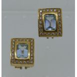 A pair of 18ct yellow gold rectangular earrings, formed of a facetted central emerald cut pale