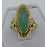 A 14ct yellow gold oval Dress Ring, with a narrow cabchon jade centre within a gold sunburst border,