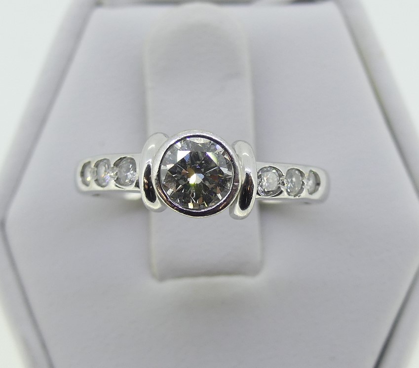 A diamond Ring, the central brilliant cut stone collet set c.½ct, with three small diamonds let into