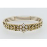 An attractive Edwardian seed pearl and diamond Hinged Bangle, the front set with a central