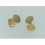 A pair of 9ct yellow gold oval Cufflinks, one side engine turned, the other plain with a small