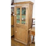 A late Victorian stripped pine upright glazed Cupboard, 72in (183cm) high x 33in (83.75cm) wide x