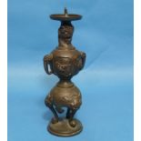 An antique Oriental bronze Candlestick, embossed in relief with three-toed dragons, dogs of Foo,