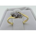 A small three stone diamond cross-over Ring, mounted in 18ct yellow gold, Size K½.