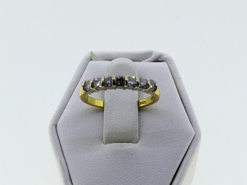 A small seven stone diamond Ring, the stones channel set in white and yellow gold marked 750, approx