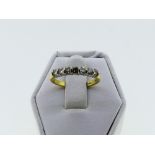 A small seven stone diamond Ring, the stones channel set in white and yellow gold marked 750, approx