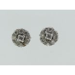 A pair of small diamond cluster Ear Studs, the central stone with eight diamonds around, all mounted