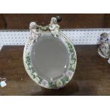 A late 19th century continental porcelain oval easel Mirror, the frame applied with roses and