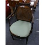 An early 20th century ebonised Bergère Armchair, with caned back and seat, together with a Victorian