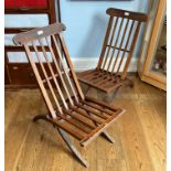 A pair of early 20thC stained pine folding Steamer Chairs, with slatted seats and backs, some worm