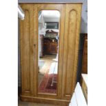 A Victorian satinwood single Wardrobe, the moulded cornice above the central door with rounded