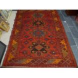 Tribal rugs; an old Caucasian Kazak red ground rug, coarsely woven and hand knotted with date