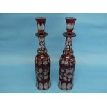 A pair of early 20thC Bohemian ruby flash Decanters, bottle shape, one with chipped stopper, 13½