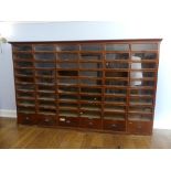 A vintage mahogany Haberdashery Cabinet, with panelled sides, the moulded cornice above 54 glass